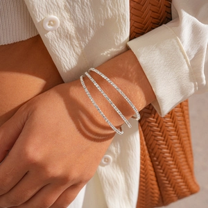 Detailed close-up of three-layer silver geometric bracelets with zircon inlay on model