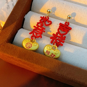Close-up of traditional Chinese lock earrings with red Auspicious and Ruyi characters