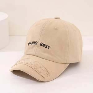 Detail of beige cotton baseball cap with Paris Best embroidery and distressed brim texture
