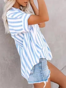 Side view of woman wearing blue and white striped short sleeve button-up shirt with denim shorts