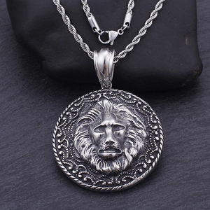 Macro shot of retro lion head pendant in antique silver with textured steel relief