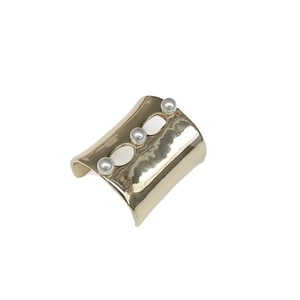 Elegant gold U-shaped hair clip with three white pearls on a minimalist metal base