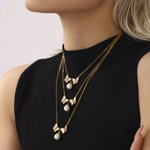 Collier doré à trois rangs avec pendentifs papillon en nacre et perles baroques sur mannequin