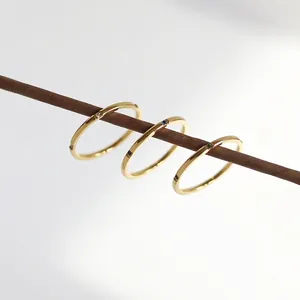 Three-piece set of thin 18K gold-plated rings with colorful crystal stones on wood branch