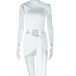 Détail d'un ensemble deux pièces blanc avec top court asymétrique et mini-jupe drapée