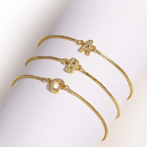 Bracelets lettres A B C dorés avec pendentifs en zircone sur support de luxe blanc