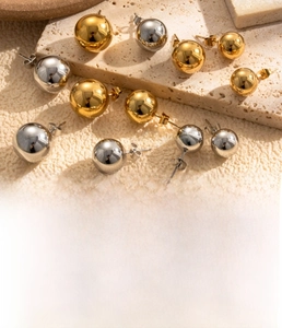 Detailed view of spherical titanium steel earrings in gold and silver vacuum plating