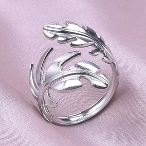 Macro view of matte silver leaf ring with detailed plant texture on pink silk background