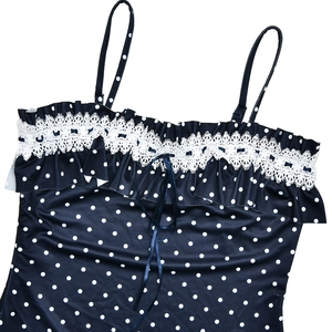 Close-up of blue polka dot dress with white lace trim and front tie detail