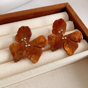 Detail view of amber resin butterfly earrings with sparkling rhinestones and gold accents