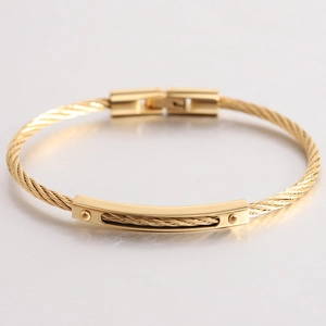 Makroansicht der 18K Gold-Kabelarmreif mit polierten Metallperlen und feiner Textur