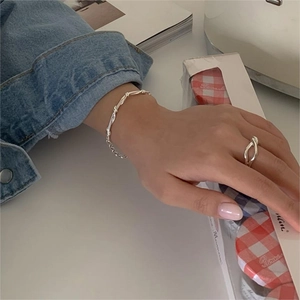 925 Sterling silver twisted knot ring and rope chain bracelet on model with denim jacket