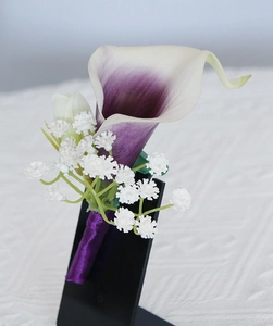 Detail of purple calla lily wedding corsage with baby's breath and violet ribbon wrap