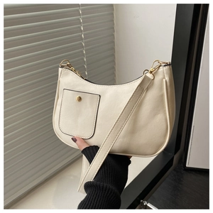 Detail of cream white PU leather shoulder bag featuring gold hardware and a small front pocket