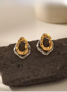 Detailed view of layered wavy metal earrings with gold and silver color blocking