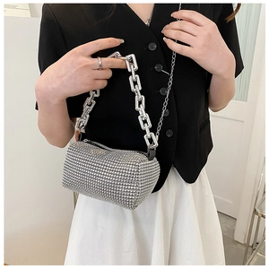 Close-up detail of silver rhinestone cylinder bag with large metal chain handle