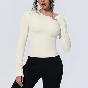 Détail d'un haut de yoga beige à manches longues et coupe ajustée au tissu respirant