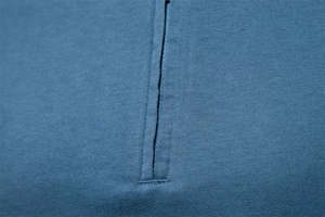 Macro shot of detailed zipper closure on premium blue cotton knit v-neck polo shirt