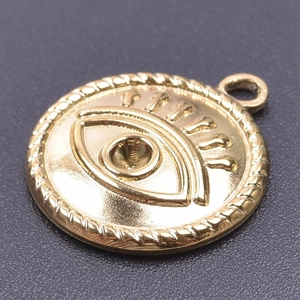 Macro detail of 18k gold plated evil eye pendant with embossed texture and rope border