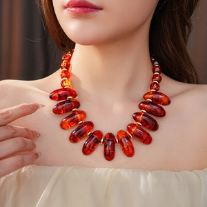 Close-up of amber beaded necklace with irregular geometric oval beads and gold spacers