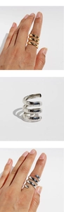 Detailed view of gold and silver bamboo texture spiral layered rings on hand