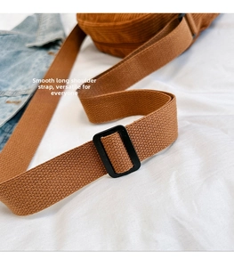Detail of adjustable brown woven corduroy bag strap with smooth sliding buckle