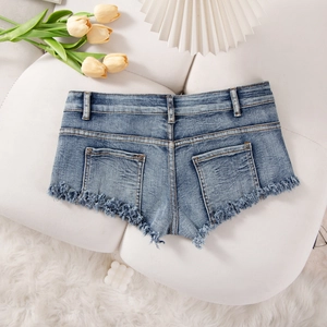 Detailansicht der blauen Denim-Shorts mit starker Waschung und Vintage-Fransenrand