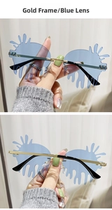 Detail view of gold frame blue lens teardrop sunglasses with creative droplet design