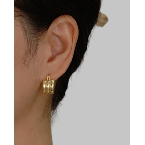 Minimalist s925 silver triple layer gold hoop earrings worn by a model in a close-up view
