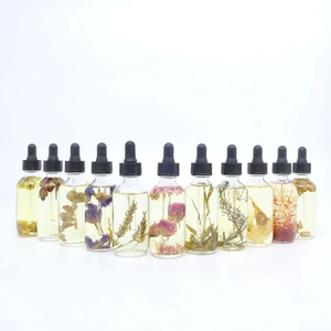Set of 11 glass dropper bottles with infused dried flowers and essential body oils