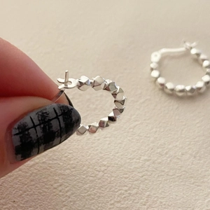 Close-up of geometric S925 sterling silver beaded hoop earrings with a secure clasp