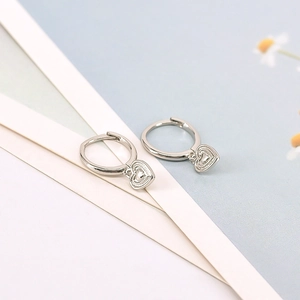 Elegant S925 silver heart drop earrings featuring polished hoops and minimalist dangles