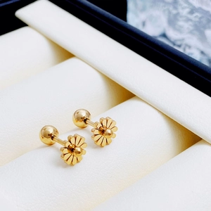 Exquisite gold titanium daisy flower screw back stud earrings on white display stand