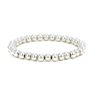 Detail of high-polish silver metal beads on a minimalist elastic bracelet over white background