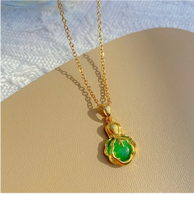 Vue macro d'un collier doré avec un pendentif en pierre verte en forme de chou