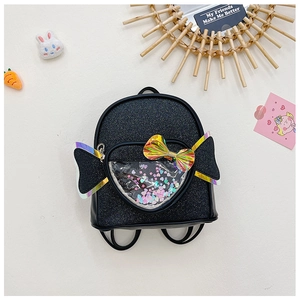 Detail of sequin backpack featuring transparent heart window and colorful bow decoration