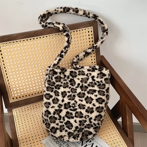 Macro shot of fluffy leopard print plush shoulder bag on vintage wicker chair