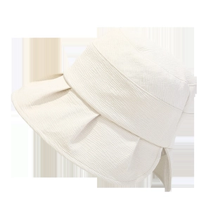 Close-up of cream textured fabric and wide wavy brim of this foldable sun bucket hat