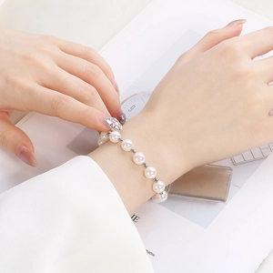 Close-up of white pearls and silver beads bracelet on wrist for a French romantic style