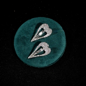 Sparkling silver alloy hollow heart hair clips with crystals on green velvet base