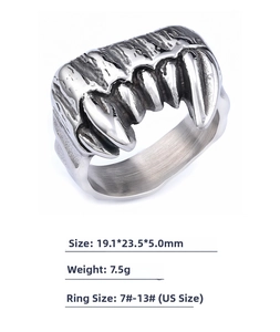 Close-up of vintage stainless steel gothic ring with detailed fang and skeleton design