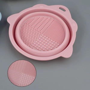 Detail of pink silicone makeup brush cleaning mat showing varied textured surfaces