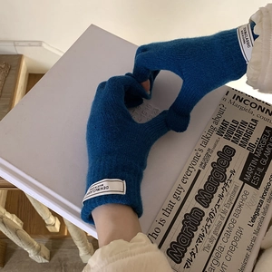 Detail of blue knitted touch screen gloves with heart gesture and brand label