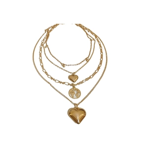 Layered gold necklace featuring heart pendants and world map charm on white background