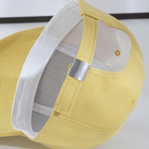 Detail of yellow baseball cap featuring adjustable silver metal buckle and interior sweatband