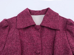 Close-up of elegant burgundy tweed jacket featuring lapel collar and matching buttons