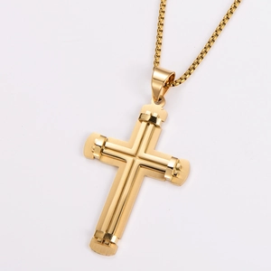 Detailed view of two-tone stainless steel cross pendant with gold finish on white background
