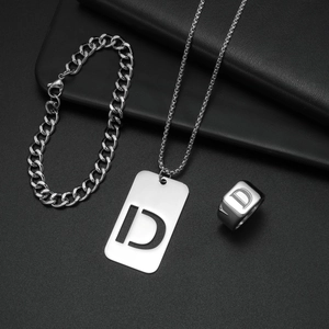 Details des silbernen Edelstahlschmuck-Sets mit graviertem Buchstaben D auf Anhänger und Ring