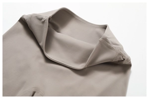 Close-up of the double-needle flatlock seams on high-waist taupe yoga leggings