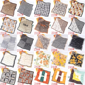 Collection of 25 silk square scarves with classic chain and geometric prints displayed in a grid
